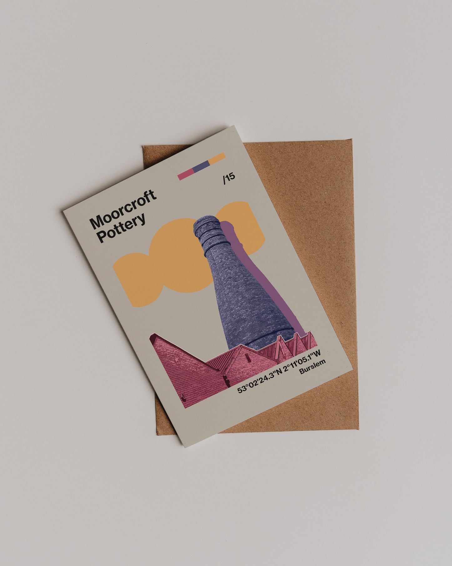 The Moorcroft Pottery Greetings Card features a stylized illustration of a tall chimney and rooftops, and is displayed atop a brown envelope against a white background.